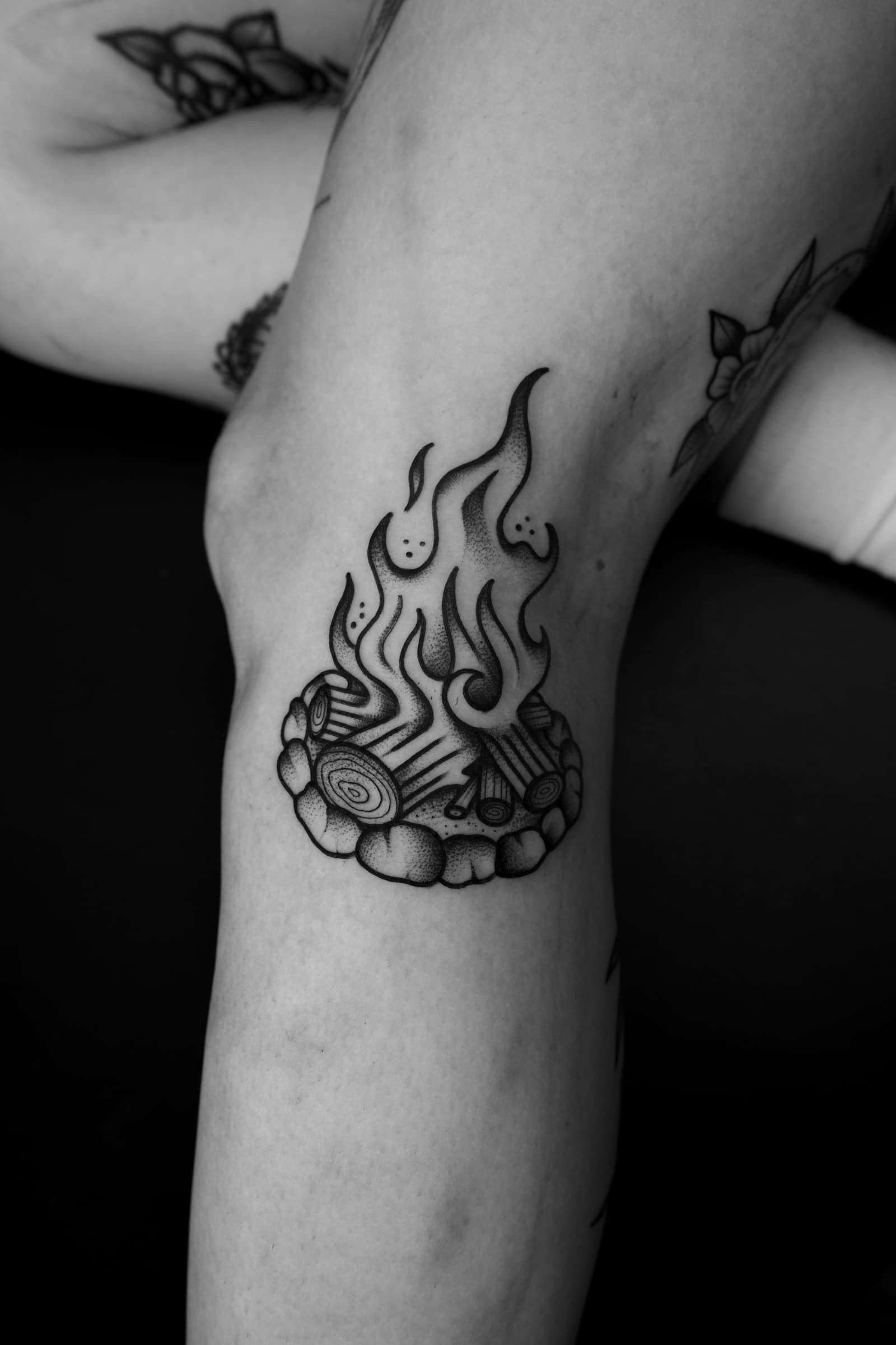 Tatouage traditionnel noir et gris d’un feu de camp