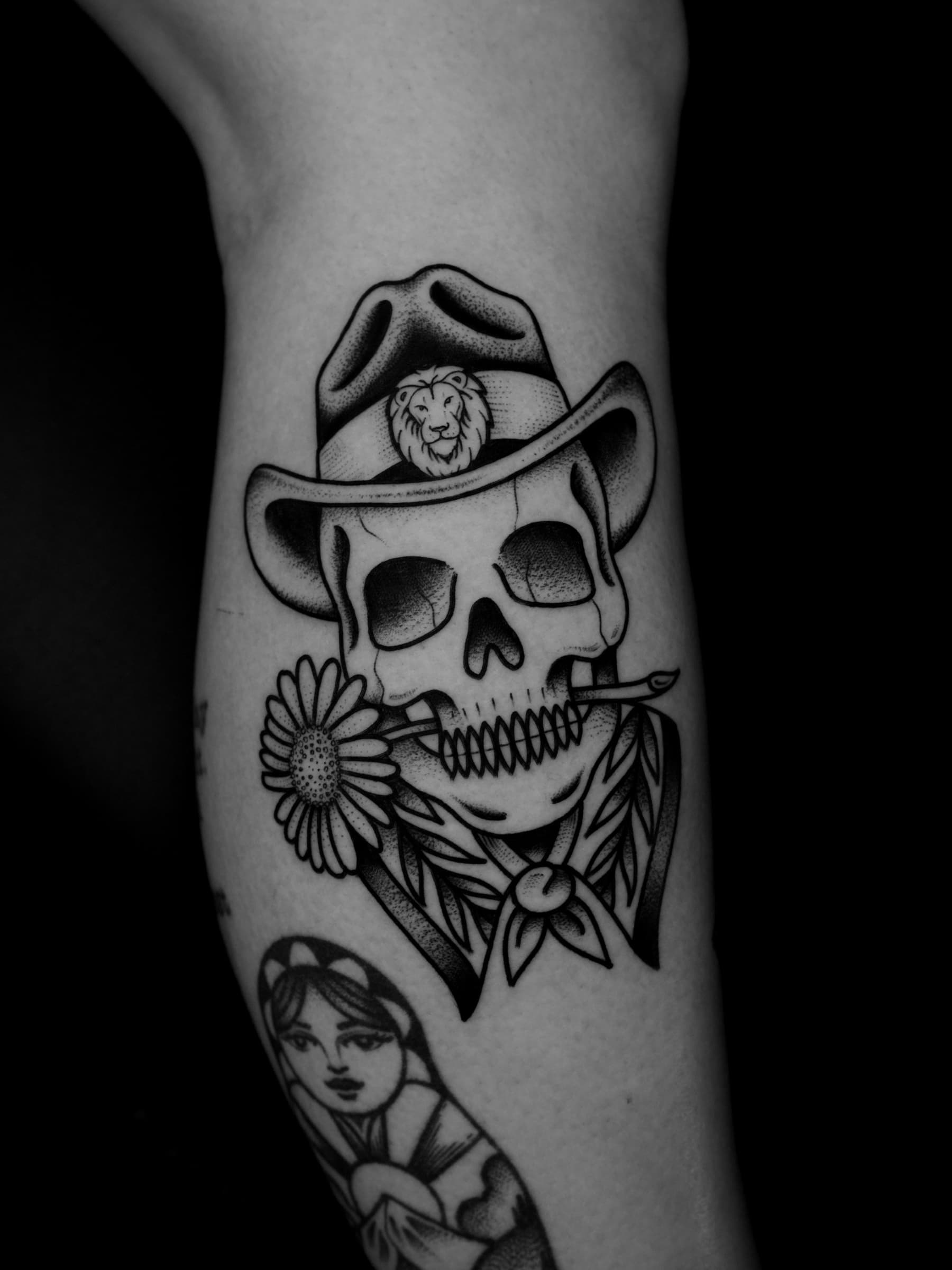 Tatouage noir et gris d’un crâne de cowboy avec une fleur