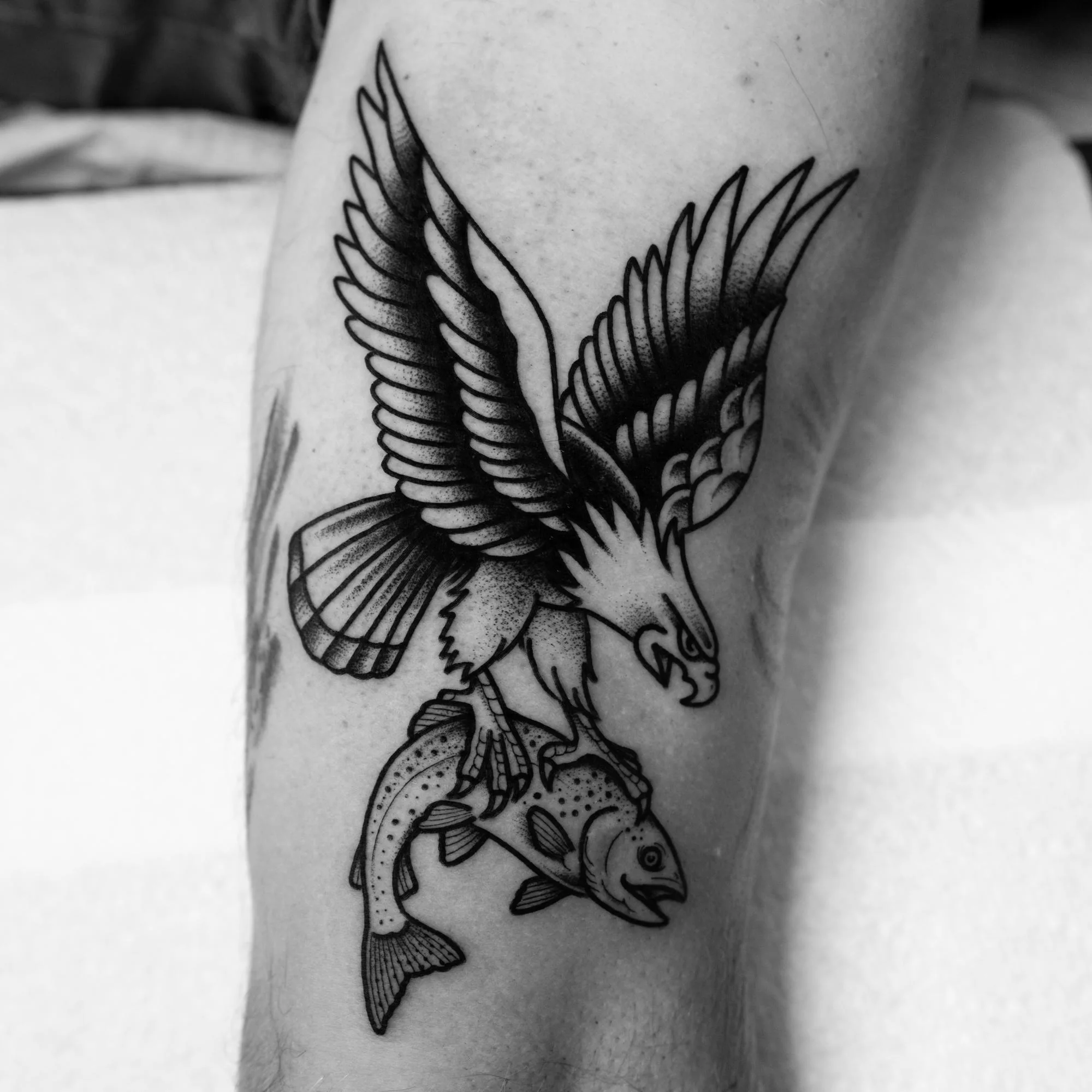 Tatouage traditionnel noir et gris d’un aigle et d’un poisson